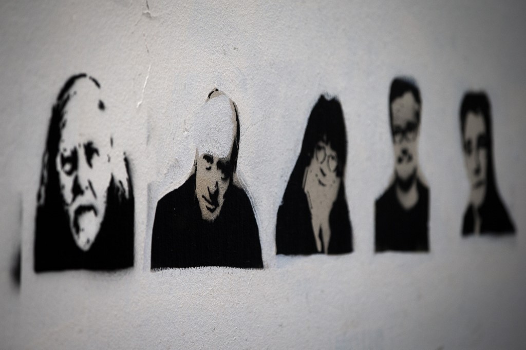Pochoirs de l’artiste français Rob.Ink représentant (de g. à d.) Honoré, Wolinski, Cabu, Charb et Tignous sur un mur près du siège de Charlie Hebdo à Paris un an après l’attaque (AFP)