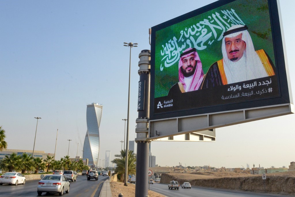 An electronic billboard bears the portraits of Saudi King Salman bin Abdulaziz and his son, the crown prince, in Riyadh on 18 November (AFP)