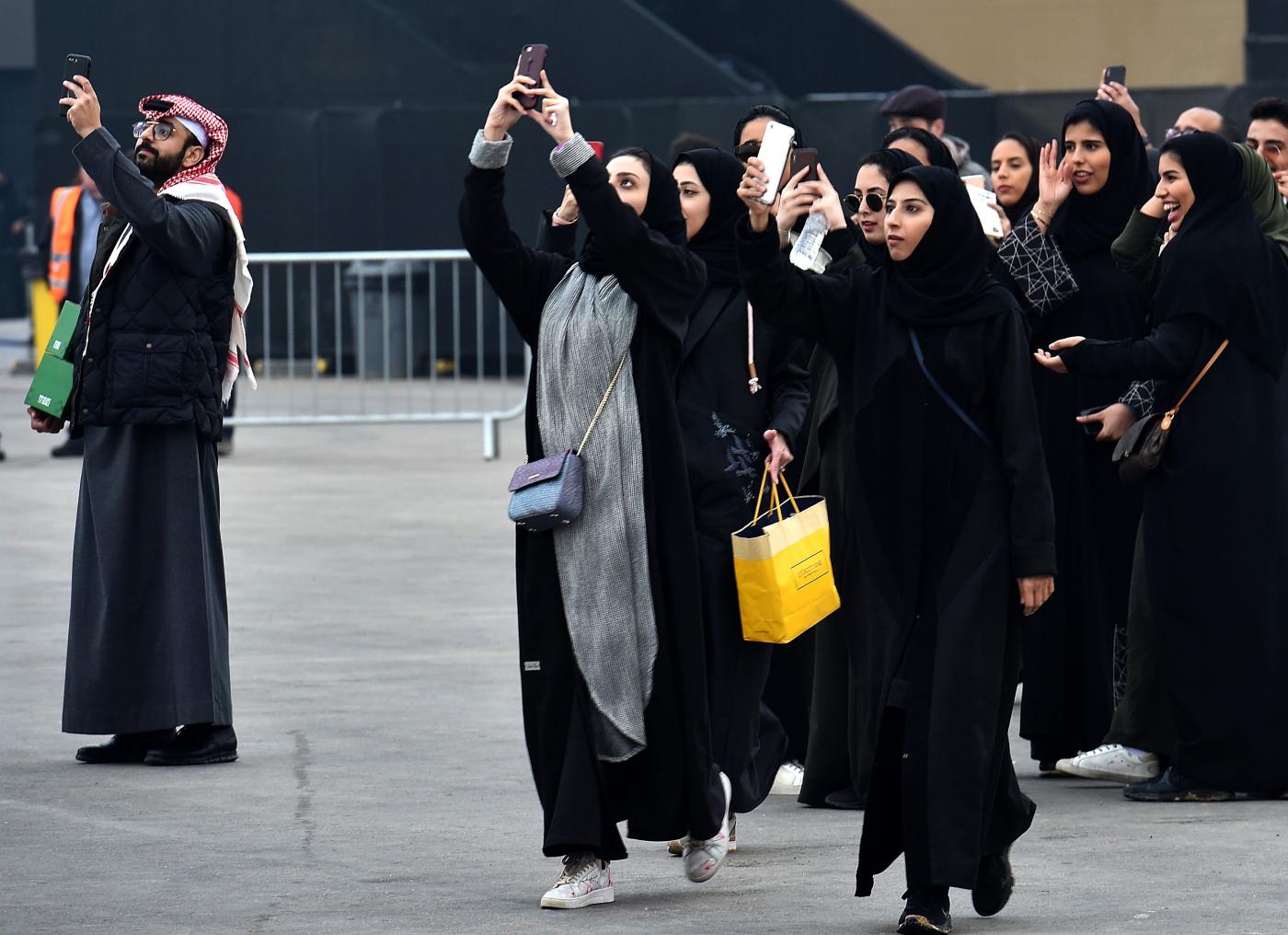Saudi women take photographs with their mobile phones prior to Saudia Ad Diriyah E-Prix Formula E Championship in Riyadh, on 15 December, 2018 (AFP)