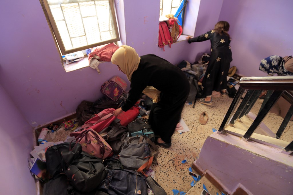 Yemeni women search through the belongings of students Al-Ra'ai School in Sanaa (AFP)