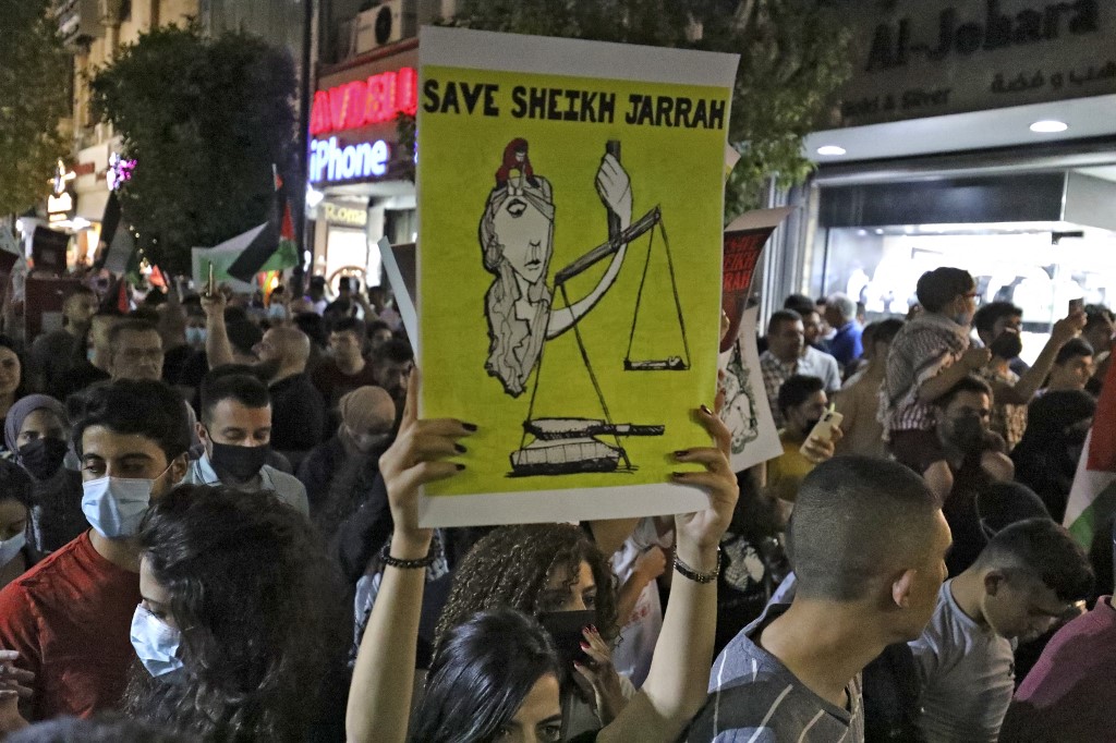 Palestinians in Ramallah protest in solidarity with Palestinian families facing expulsion in Jerusalem’s Sheikh Jarrah neighbourhood on 9 May 2021 (AFP)