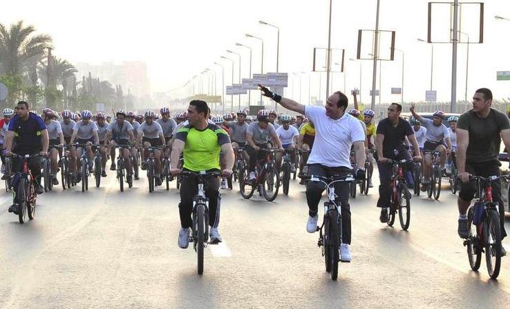 President Sisi riding a bike with hundreds of people in Cairo in June 2014 (Egyptian Presidency/Reuters)