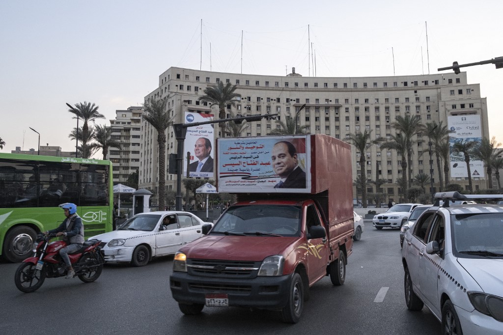 A motorist drives a pickup truck carrying an electoral sign by a private retailer endorsing incumbent Egyptian President and independent presidential candidate Abdel Fattah al-Sisi along the main roundabout in Cairo's central Tahrir Square on December 1, 2023, ahead of the upcoming 2024 presidential elections scheduled for December 10.