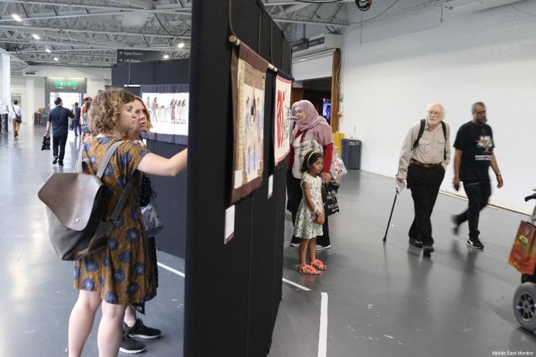 PALEXPO visitors look at the Palestinian tapestries on display on 6 July [Courtesy of Middle East Monitor]