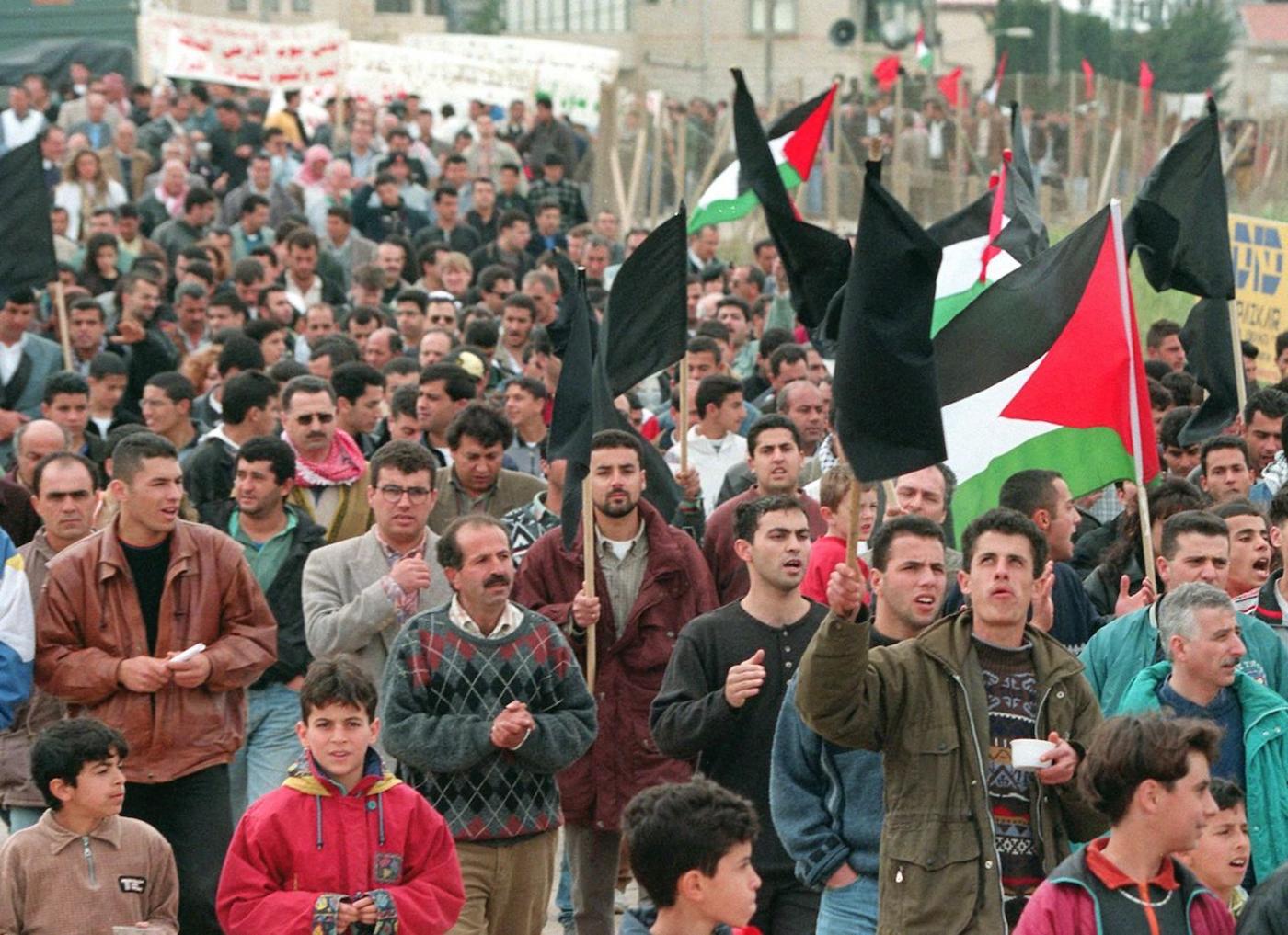 Palestinians holding black and Palestinian flags march 30 March 1998 in Sakhnin on the anniversary of the killing here in 1976 of six Israeli Palestinians protesting land confiscations by Israel (AFP)