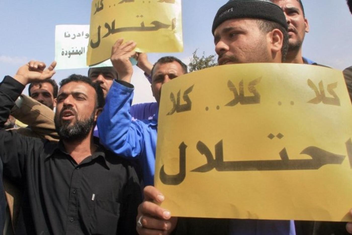 Employees of the southern Basra province energy company carry placards that read "no for occupation" and shout slogans during a demonstration in front of the British consulate in Basra, 2007 (AFP)