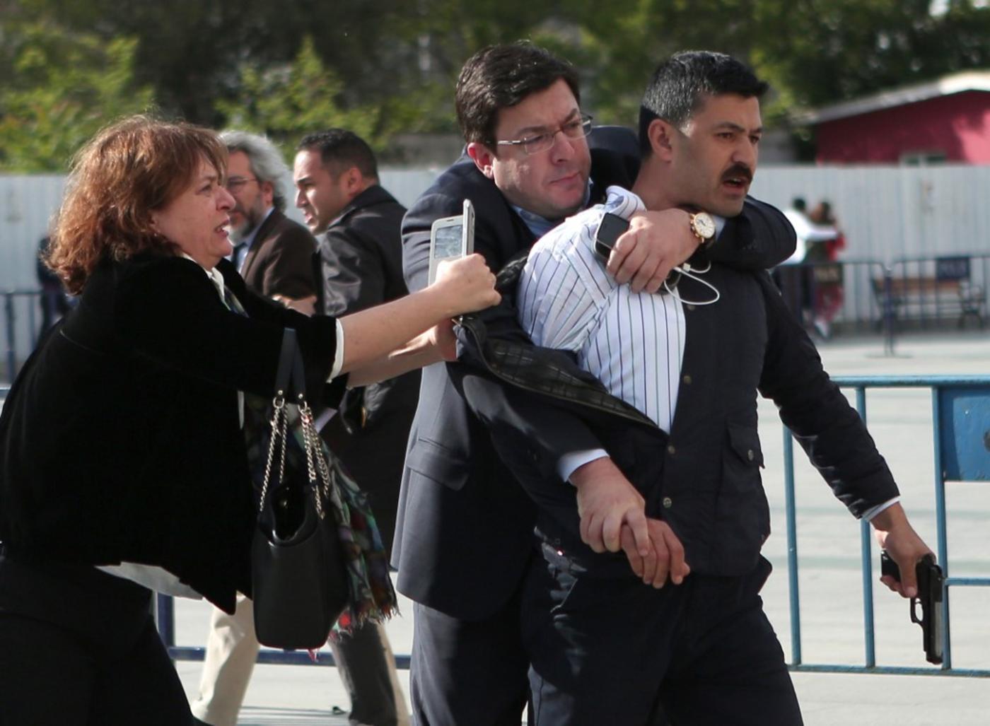 Dilek Dundar, the wife of Cumhuriyet editor in chief Can Dundar, trying to stop a gunman from firing shots outside a courthouse in Istanbul (Cumhuriyet/AFP)
