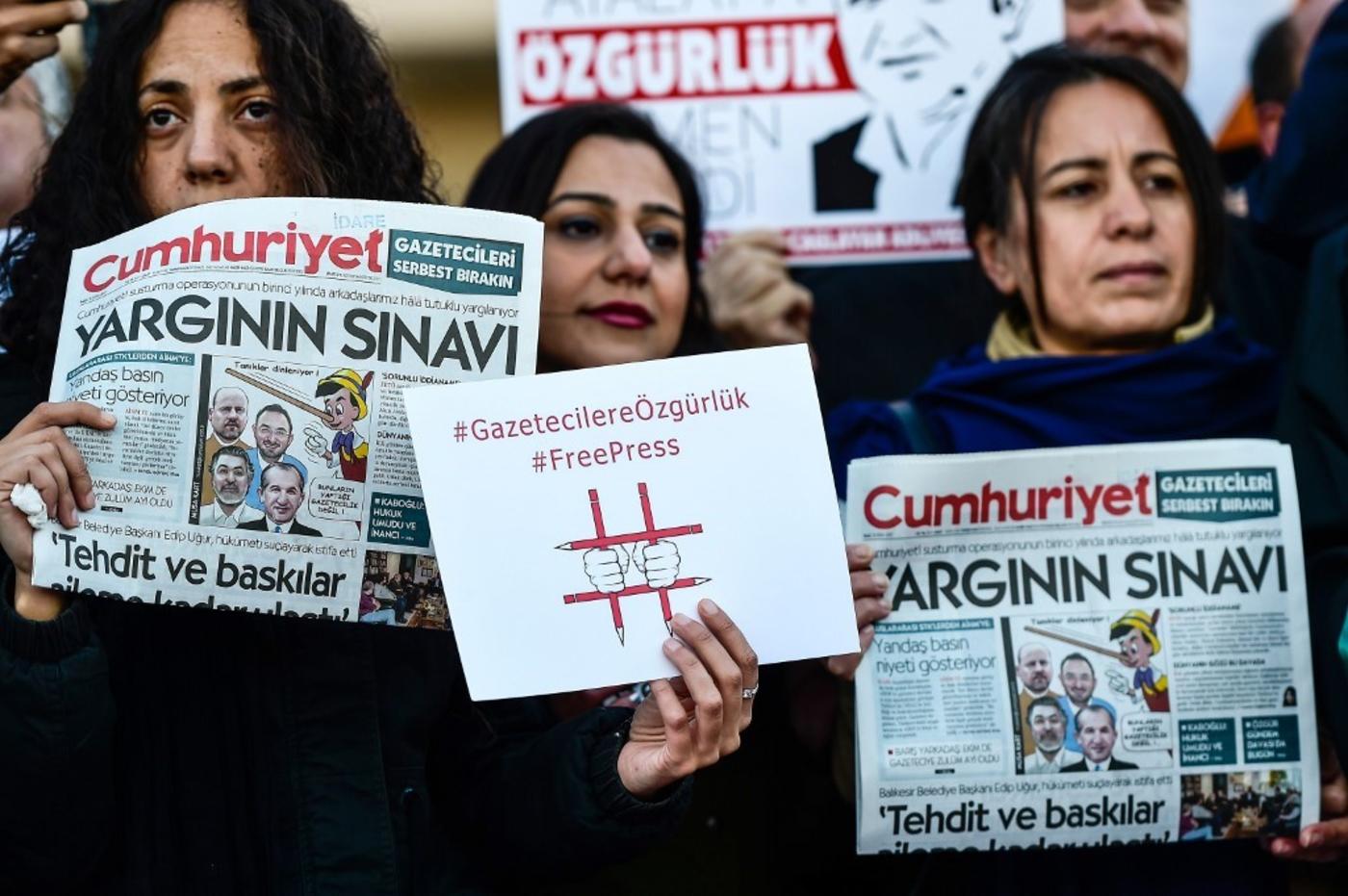 Protesters hold copies of Turkish daily newspaper Cumhuriyet and placards during a demonstration in front of a courthouse in Istanbul on 31 October 2017. (AFP) 