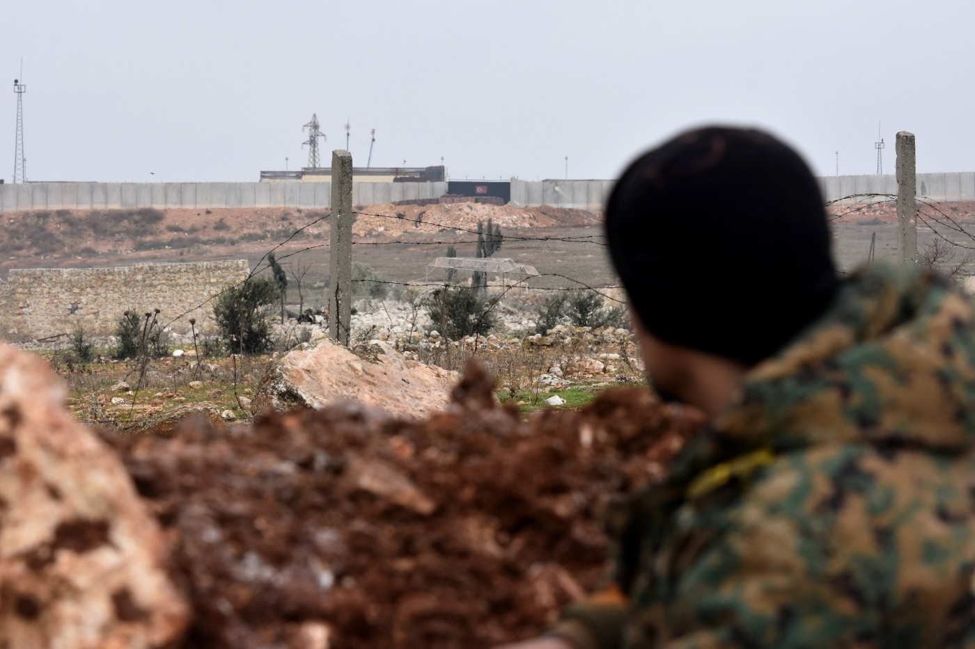 Un soldat de l’armée syrienne regarde un poste d’observation militaire turc dans le district d’al-Rashidin, dans la campagne au sud-ouest d’Alep en janvier (AFP)