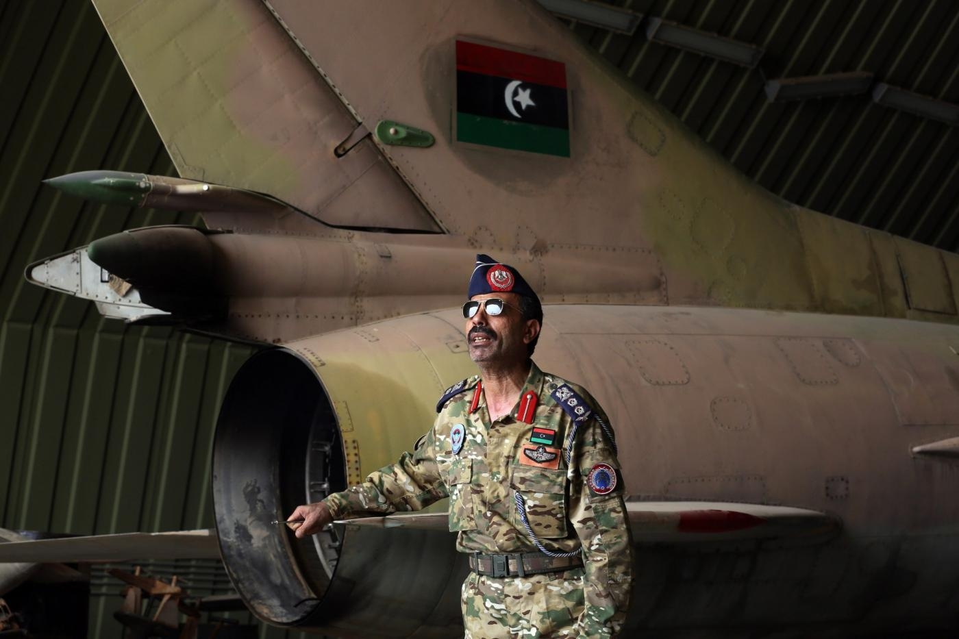 Un membre des forces armées du Gouvernement d’union nationale près d’un MiG-23 après la prise de la base aérienne d’al-Watiya en mai (AFP)