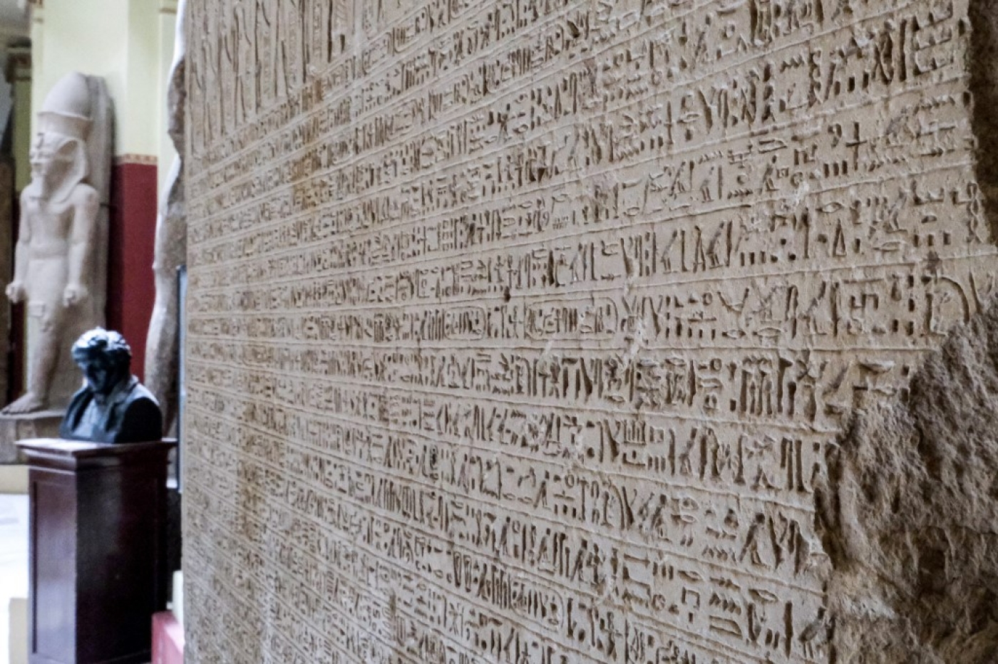 Un buste de Jean-François Champollion au Musée égyptien de la capitale égyptienne, avec à ses côtés le décret de Canope, inscrit sur une stèle. Ayant un plus grand nombre de hiéroglyphes différents que la pierre de Rosette, cette stèle s’est avérée cruciale pour déchiffrer l’écriture (AFP/Amir Makkar)