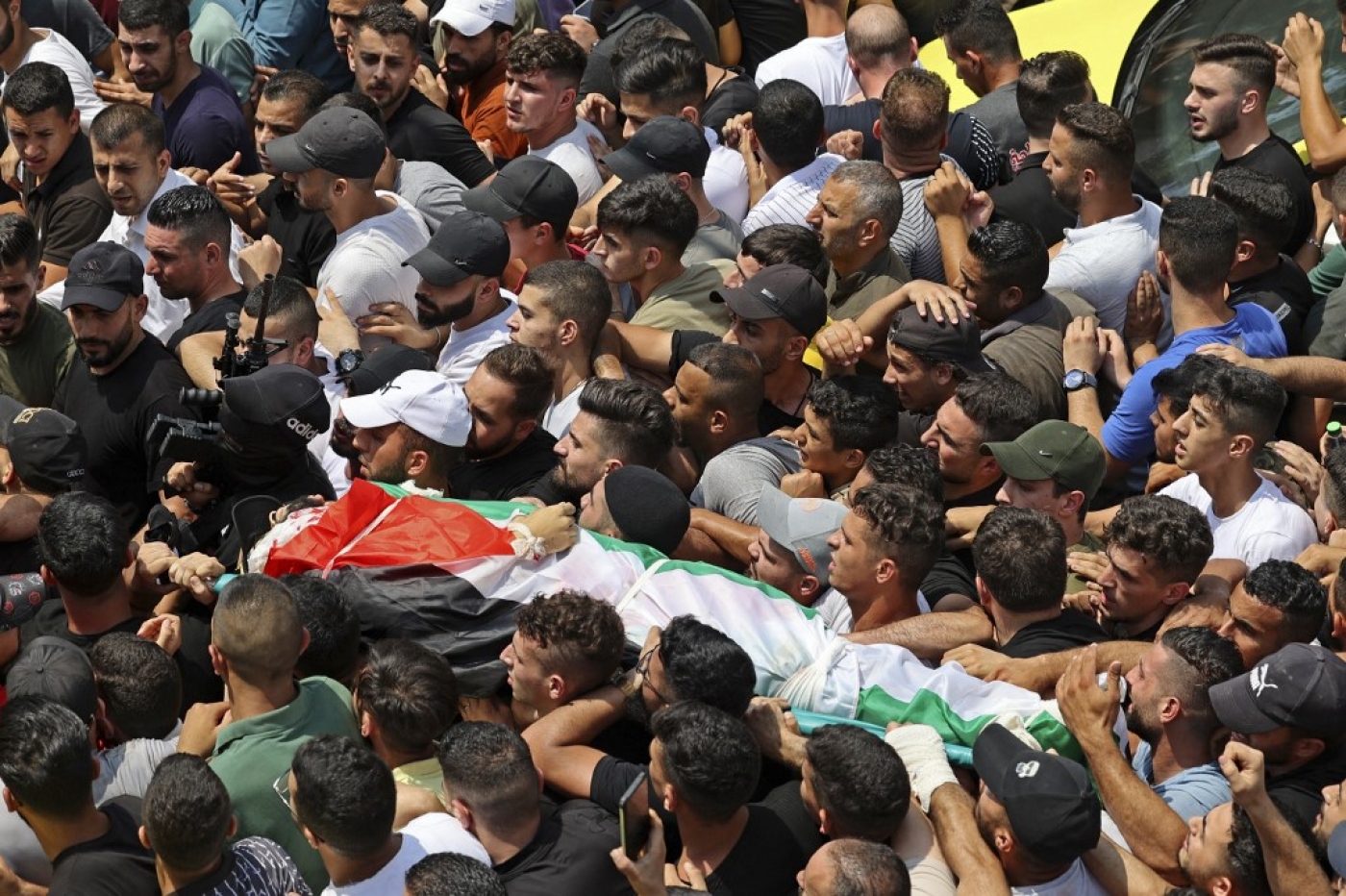 Mourners carry the body of Ibrahim al-Nabulsi, who was killed in an Israeli raid, during a funeral procession in the West Bank city of Nablus on 9 August 2022 (AFP)
