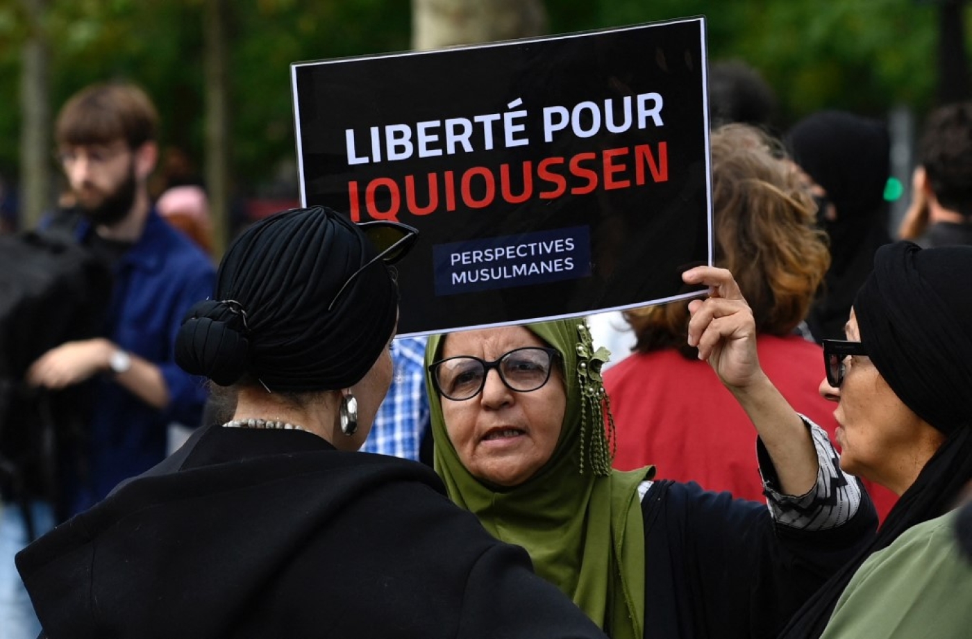Une manifestante brandit une pancarte lors d’un rassemblement de soutien à l’imam Hassan Iquioussen, place de la République à Paris le 3 septembre 2022 (AFP/Jean-Christophe Verhaegen)