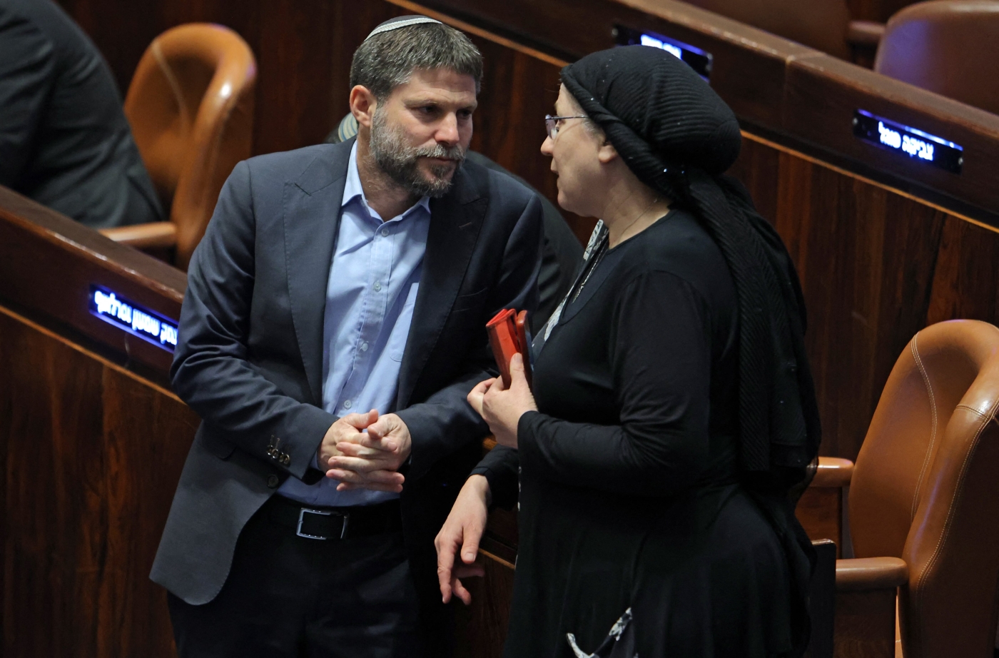 Israeli Knesset member Bezalel Smotrich (L) speaks with Orit Strook (R) during a session elect the new speaker of the assembly in Jerusalem on 13 December 2022 (AFP)