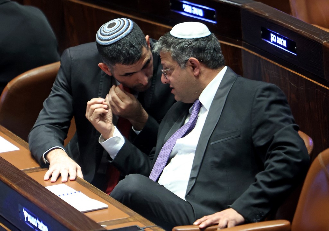 Israeli Knesset member Itamar Ben-Gvir (R) speaks with the Likud party's Shlomo Karhi (L) during a session to elect the new speaker of the assembly in Jerusalem on 13 December 2022 (AFP)