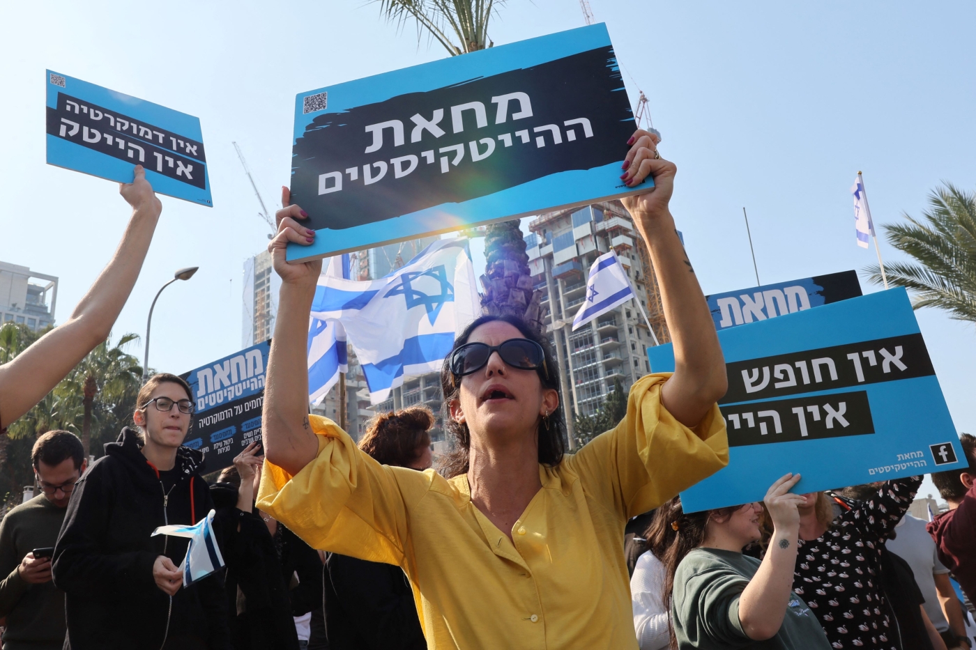 High-tech company workers block a road and lift placards as they strike for an hour in Israel's coastal city of Tel Aviv, on January 24, 2023, to protest the Israeli government's controversial plans to overhaul the judicial system (AFP)