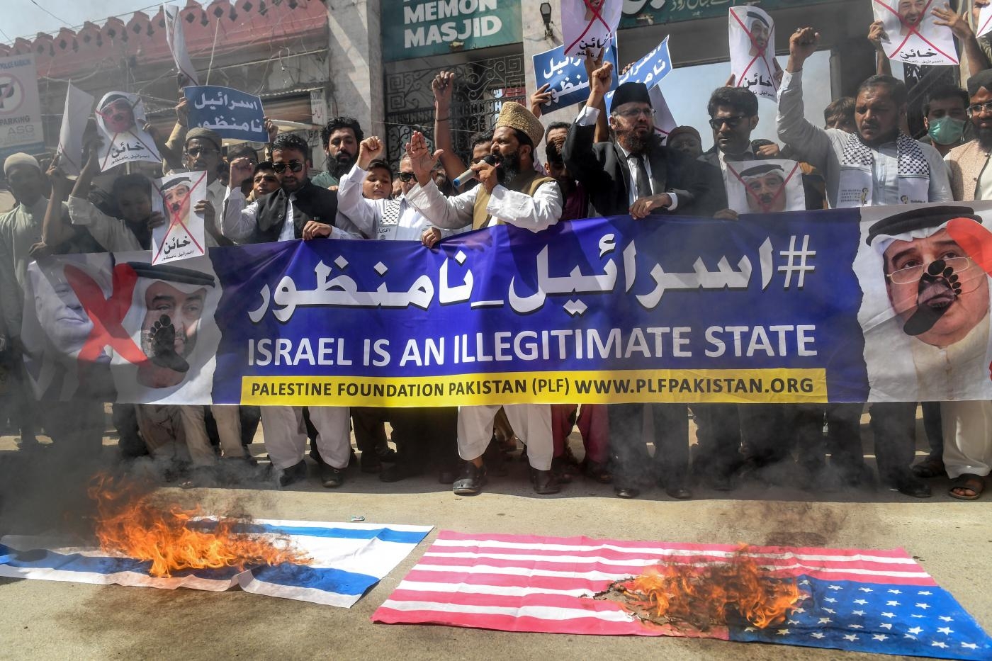 Des drapeaux israélien et américain sont brûlés au cours d’une manifestation contre la normalisation dans la ville portuaire de Karachi, au Pakistan (AFP)