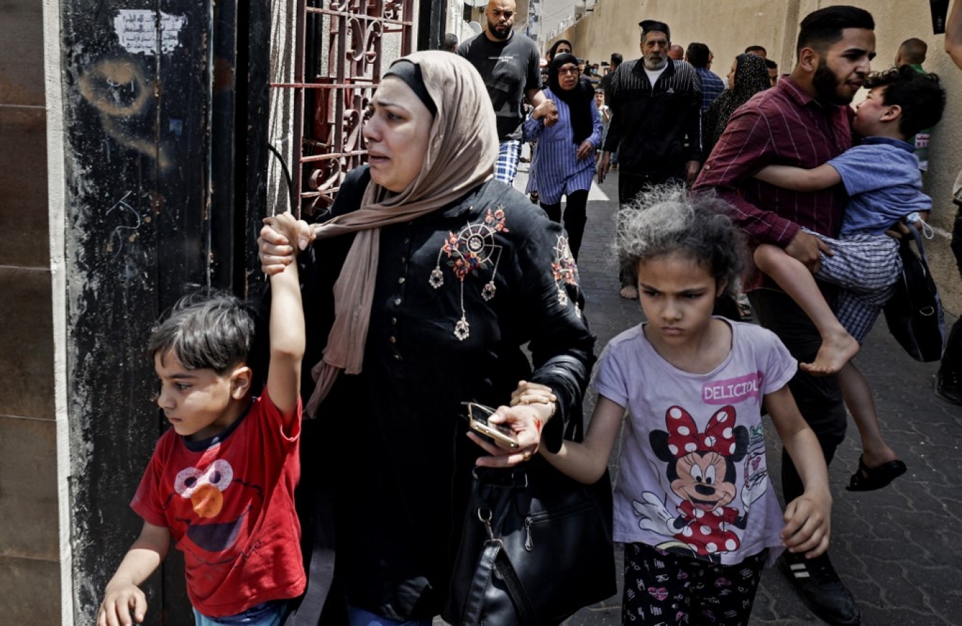 Des familles évacuent un bâtiment visé par les bombardements israéliens à Gaza, le 22 mai 2021 (AFP)