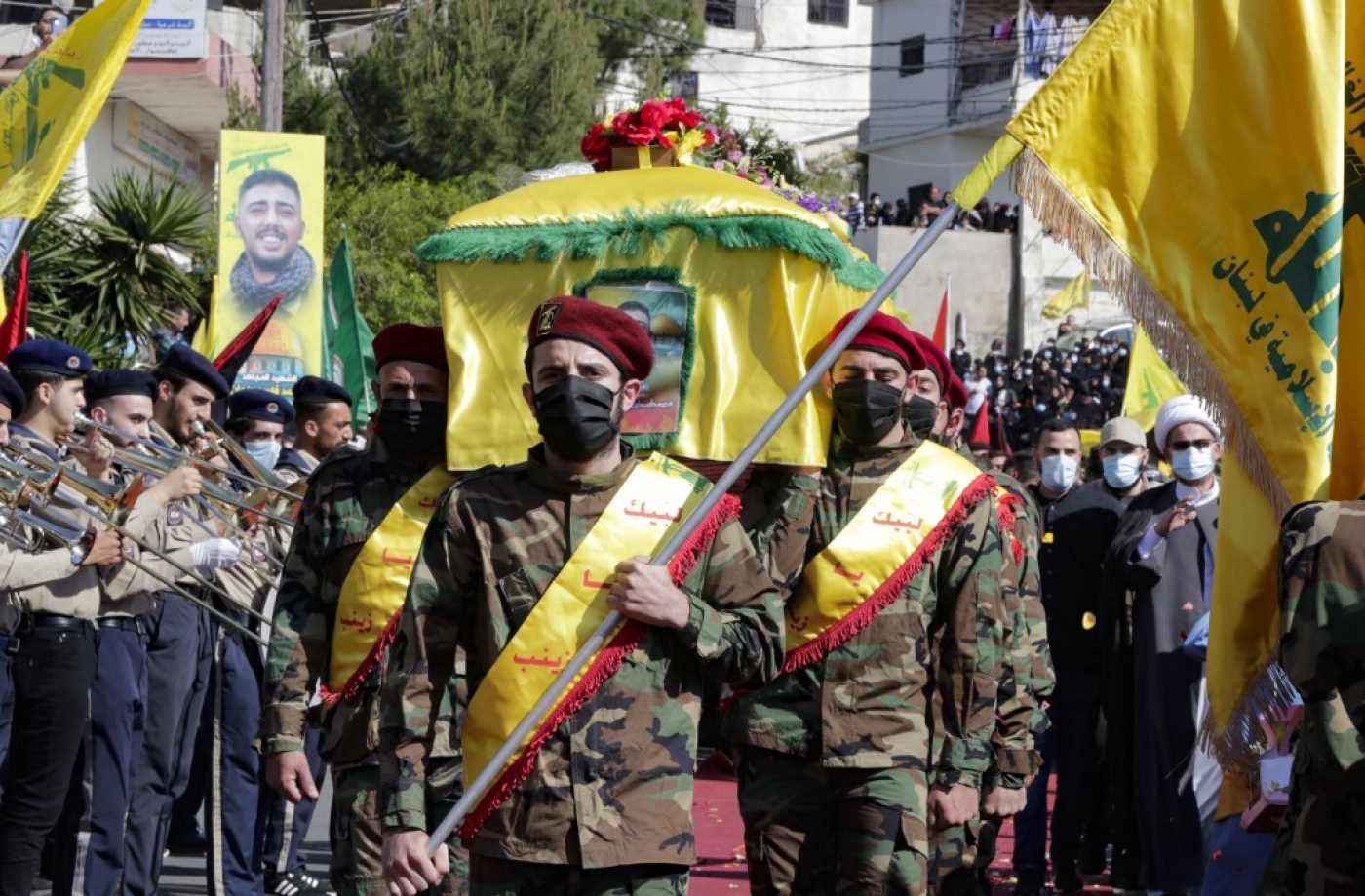 Des membres du Hezbollah portent le cercueil d’un des leurs, Mohamad Kassem Tahan, tué un jour plus tôt par des tirs israéliens à la frontière avec le Liban lors d’une manifestation contre l’offensive israélienne contre la bande de Gaza, le 15 mai 2021 (AFP/Anwar Amro)