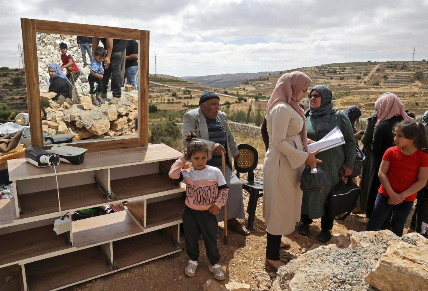 Des membres d’une famille palestinienne vérifient leurs effets personnels après la démolition par des machines israéliennes de leur maison située dans la zone C de la Cisjordanie occupée (AFP)