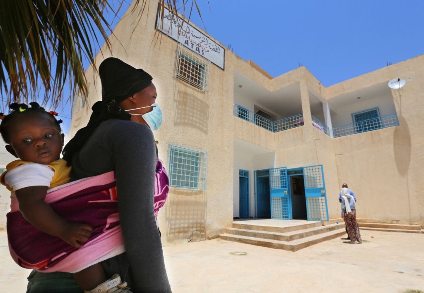 Aïcha, qui est venue de Guinée, arrive avec sa fille au centre de formation pour migrants de Médenine, au sud de la Tunisie, le 14 juin 2021 (AFP/Fathi Nasri)