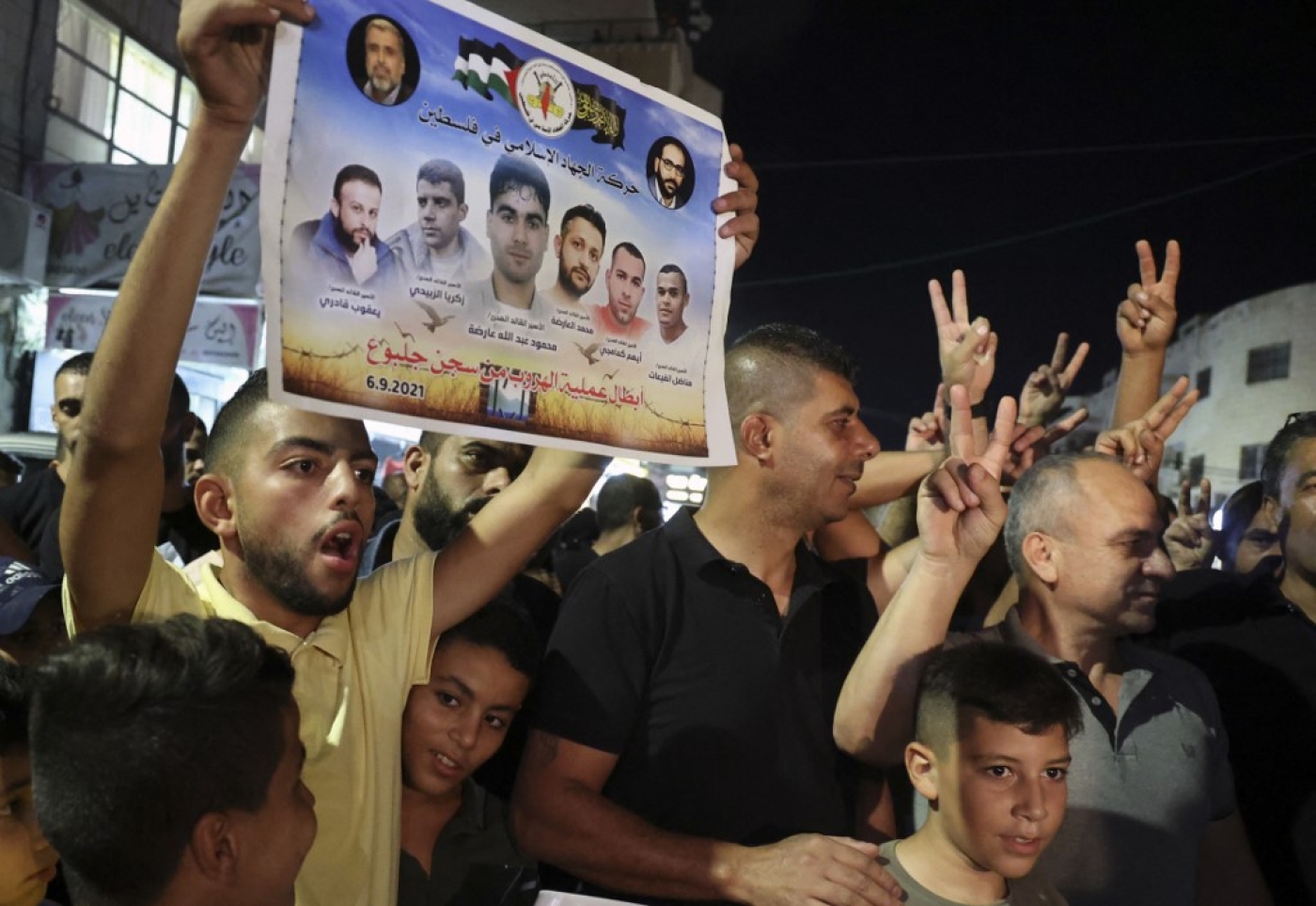 A Palestinian man shows a poster of the six Palestinians who escaped from an Israeli prison 