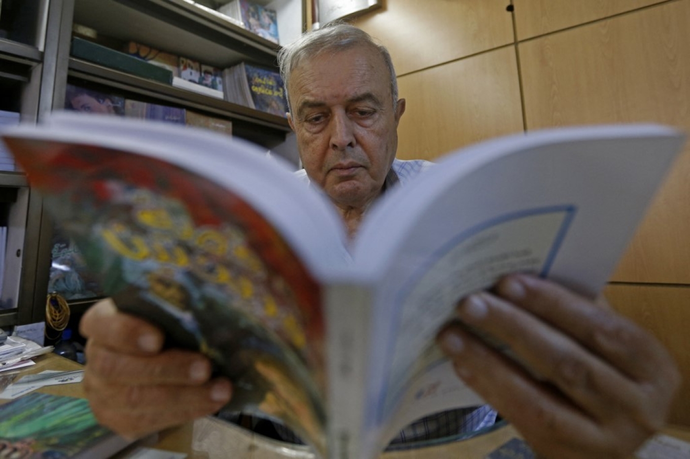 Khalil Haddad, qui travaille à la libraire et maison d’édition Dar Oussama, à Damas, consulte un ouvrage (AFP/Louai Beshara)