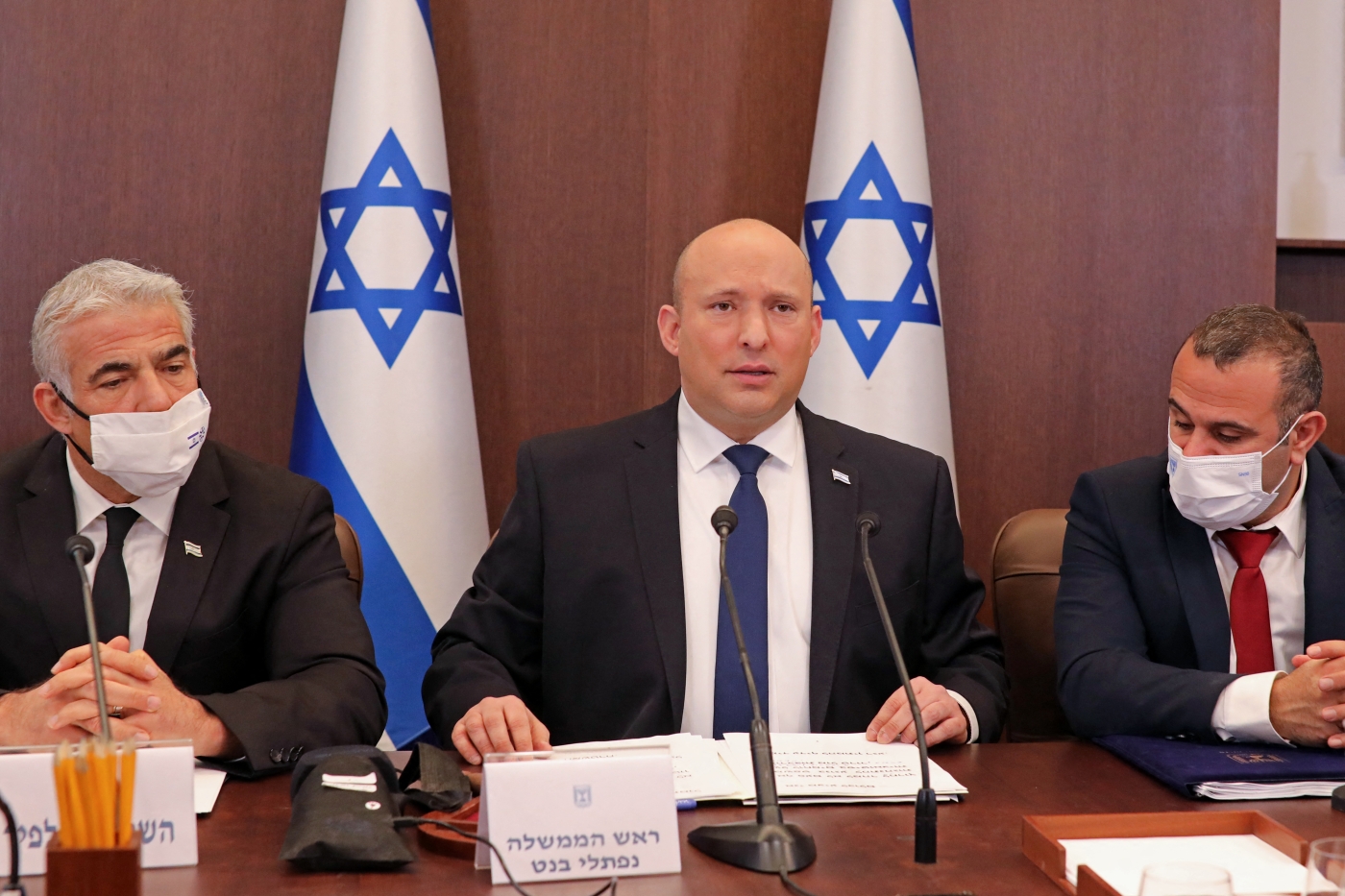 Israeli Prime Minister Naftali Bennett (C) and Foreign Minister Yair Lapid (L)