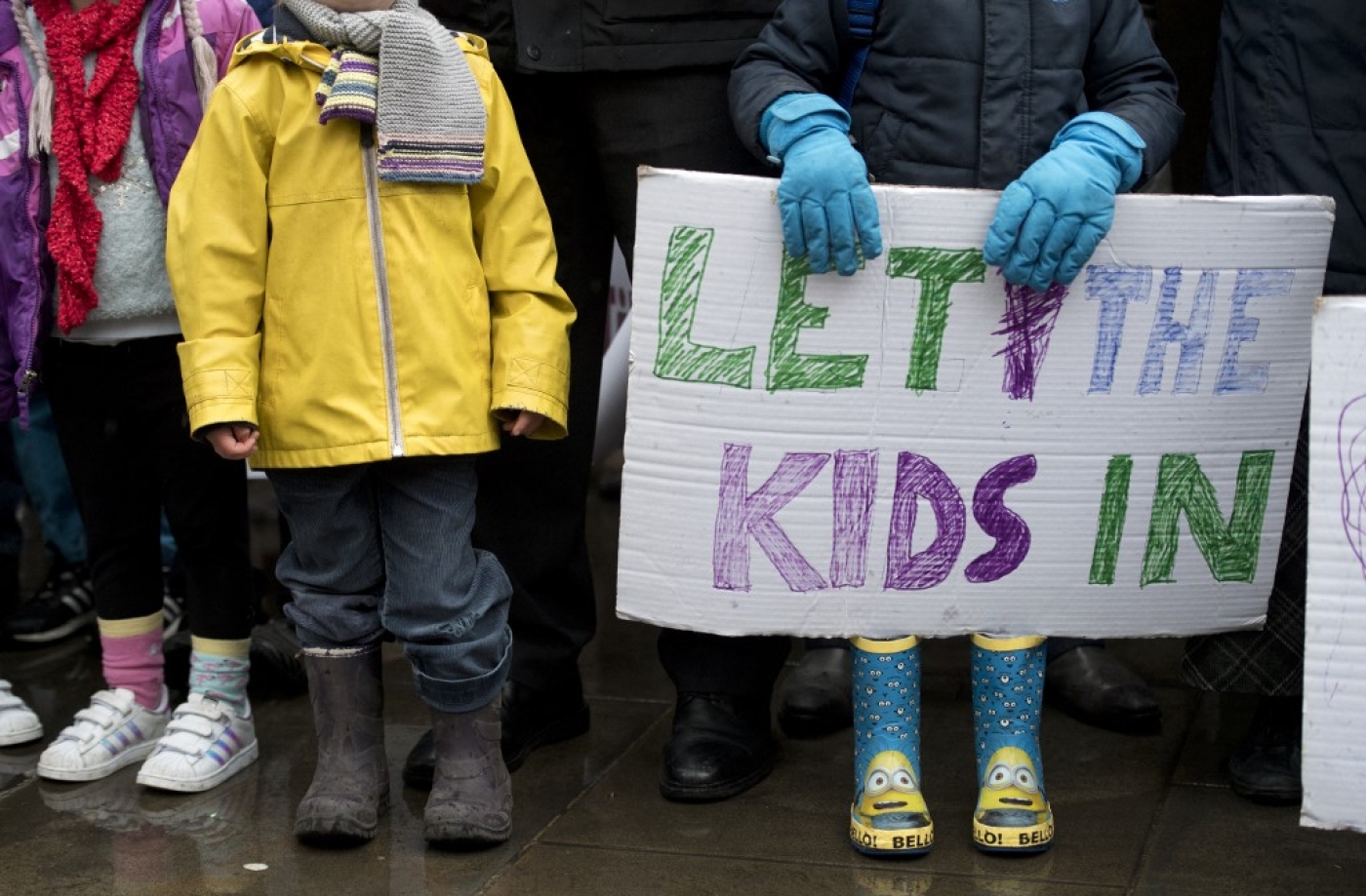 A child holds a placard that reads "Let the kids in" during a protest for refugees in London on February 11, 2017 (AFP) 