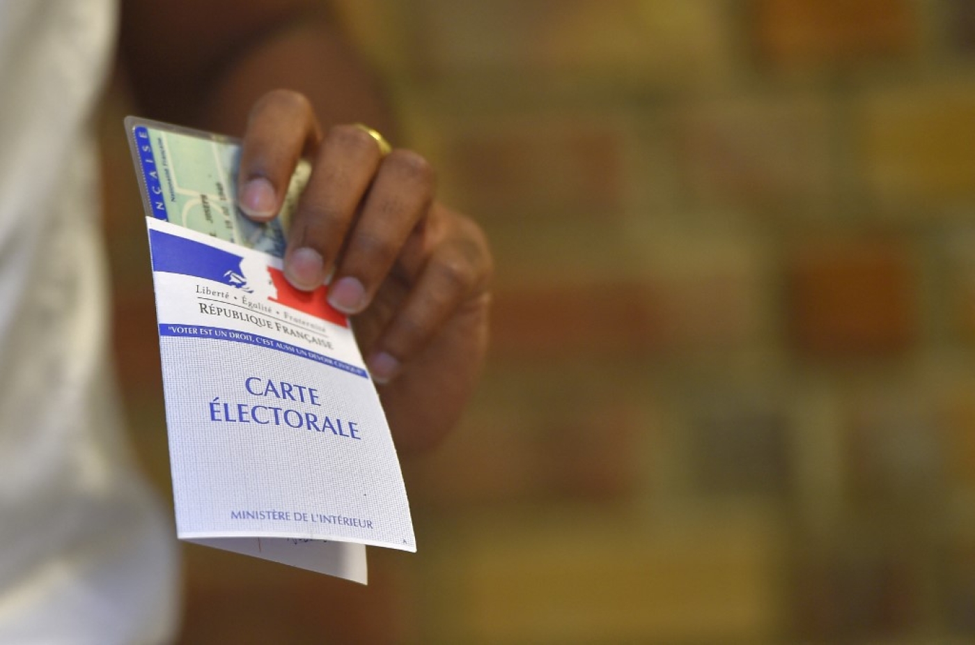 Une femme tient sa carte électorale dans un bureau de vote à Nantes, dans l’ouest de la France, lors du second tour des élections législatives françaises (élections législatives en français), le 18 juin 2017. (AFP/Loic Venance)