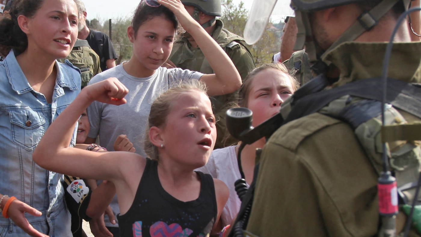 Ahed Tamimi fait face à un soldat israélien lors d’une manifestation contre la confiscation de terres palestiniennes par Israël dans le village de Nabi Saleh (Cisjordanie occupée), en 2012 (AFP)
