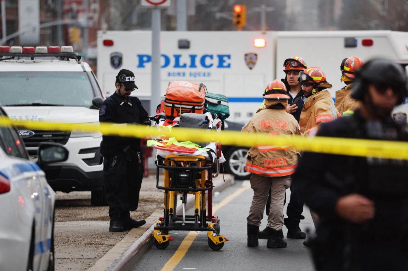 Police and emergency responders gather at the site of a reported shooting of multiple people outside a Brooklyn subway station 12 April (AFP)
