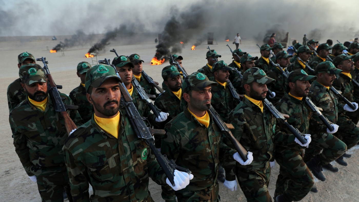 Members of the paramilitary Popular Mobilisation Forces take part in their graduation ceremony at a military camp in Karbala in 2019 (Reuters)