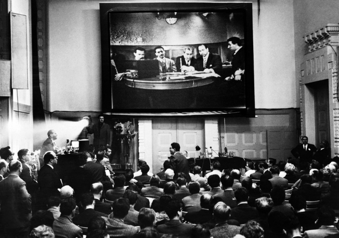 Des journalistes suivent la conférence de presse télévisée donnée le 24 mai 1961 par la délégation FLN présidée par Krim Belkacem à la Maison de la presse à Genève (AFP)