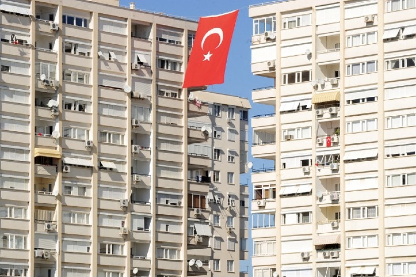 A Turkish flag flutters between apartment blocks in Antalya (File photo/AFP)
