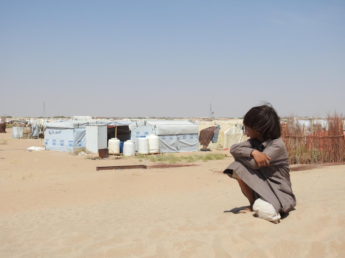 Un jeune garçon regarde des tentes dans le camp de déplacés internes d’al-Nogia’a à Marib, au Yémen (MEE/Hashem Khaled)