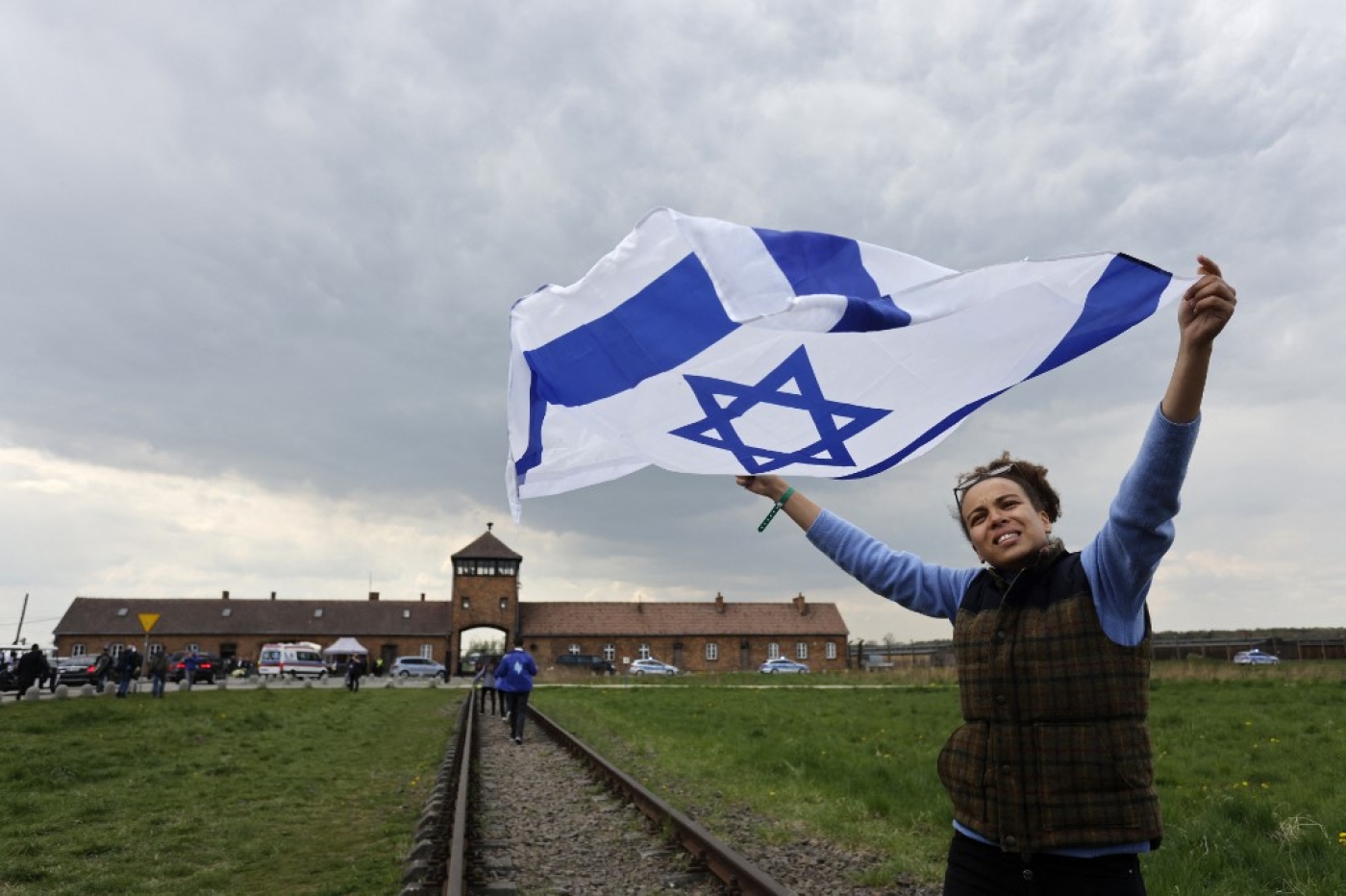 A participant holds up the Israeli flag at The March of the Living at the site of the former Auschwitz-Birkenau camp in Poland to honour the victims of the Holocaust, 28 April 2022 (AFP)