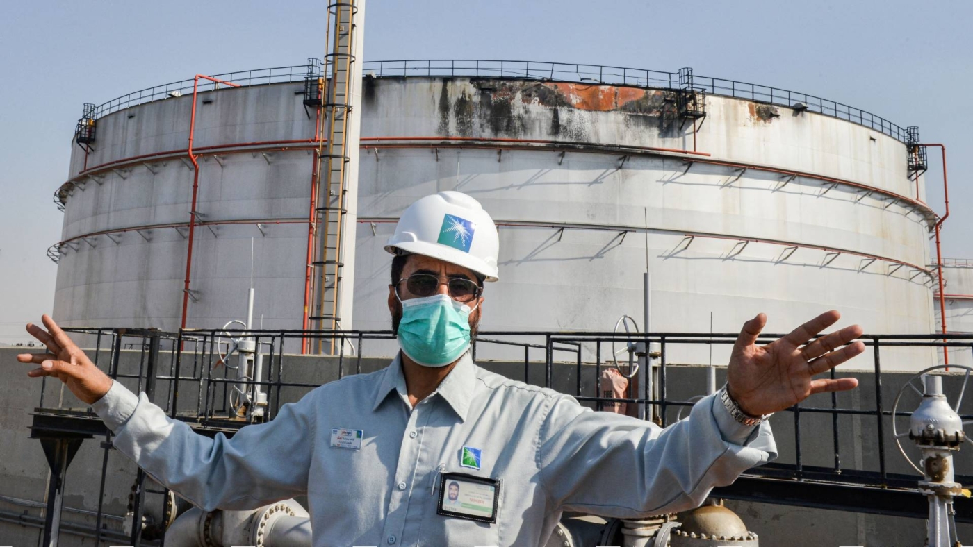 An employee at the Saudi Aramco oil facility gestures while standing near a damaged silo by a Houthis missile, at the plant in Saudi Arabia's Red Sea city of Jeddah, 24 November 2020 (AFP)