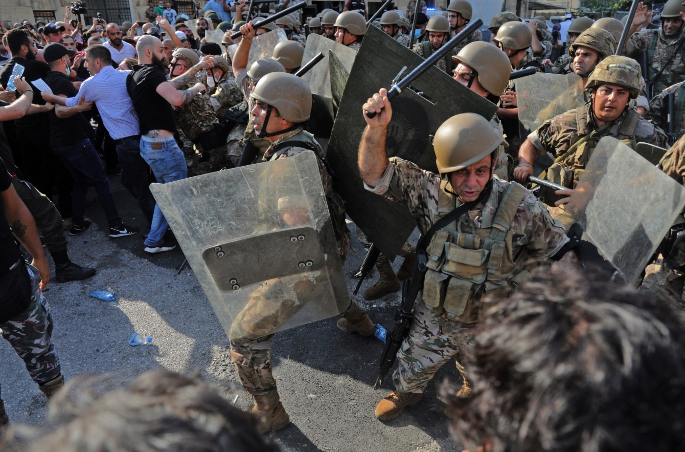 Les forces de sécurité libanaises chargent les manifestants avec des matraques à l’entrée du port de Beyrouth, le 4 août 2021, au premier anniversaire de l’explosion qui a ravagé la capitale libanaise (AFP)