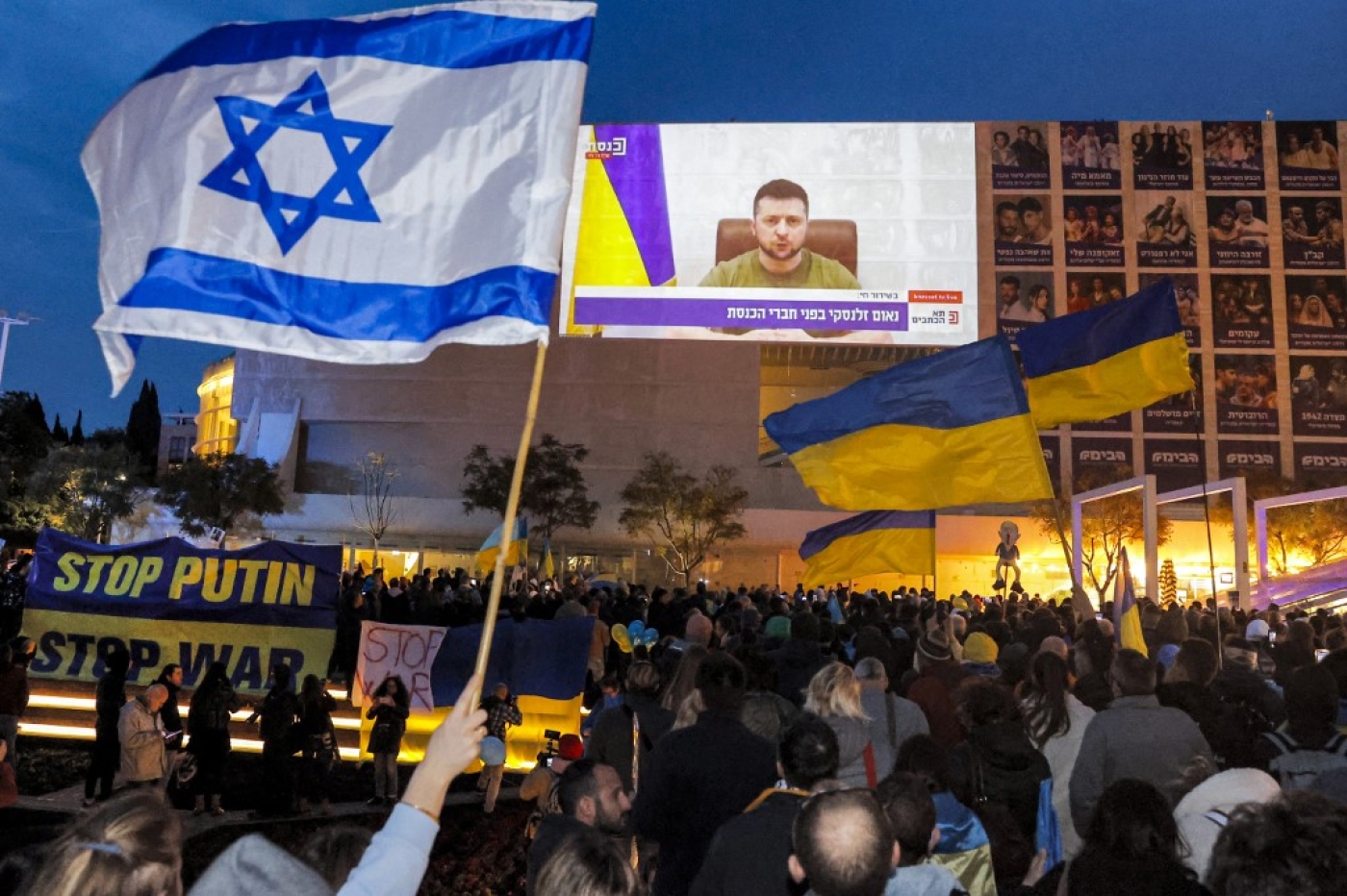 Demonstrators gather at Habima Square in the centre of Tel Aviv on 20 March 2022 to watch a televised video address by Ukraine's President Volodymyr Zelensky to the Israeli Knesset (AFP)
