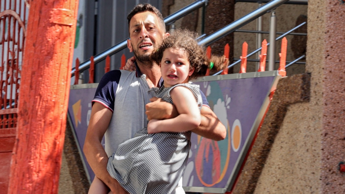 Un Palestinien porte sa fille après avoir évacué sa maison