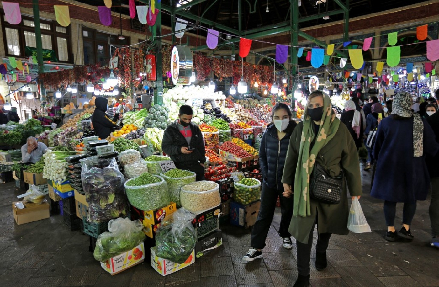 Mask-clad Iranians shop amid the Covid-19 pandemic, at the Tajrish Bazaar in Tehran on 17 March