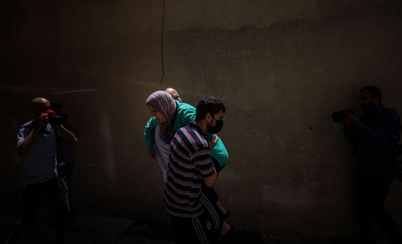 Man carries injured woman in Gaza