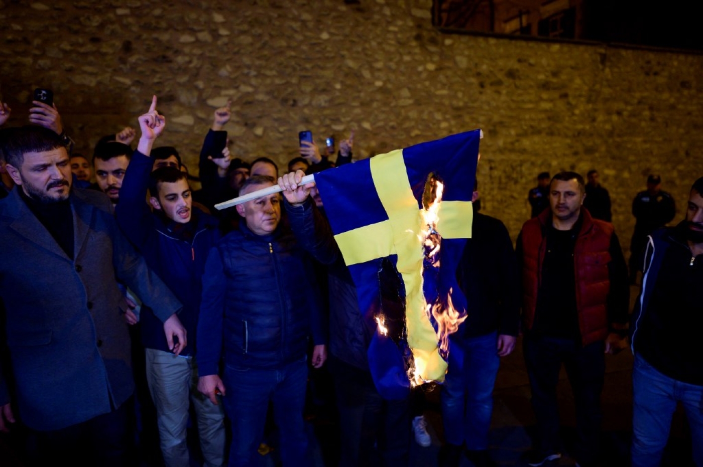 Protesters burn the national flag of Sweden as they demonstrate in front of the Consulate General of Sweden after Rasmus Paludan, leader of Danish far-right political party Hard Line and who also has Swedish citizenship burned a copy of the Koran near the Turkish Embassy in Stockholm, in Istanbul, on January 21, 2023. (AFP)