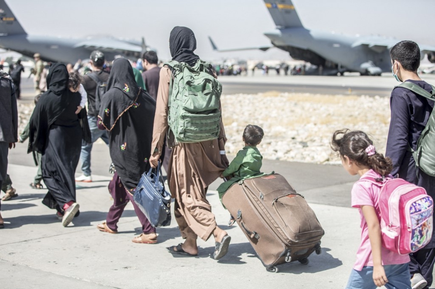 Afghan civilians head towards an aircraft during an evacuation at Hamid Karzai International Airport, Kabul, Afghanistan, on 24 August 2021.