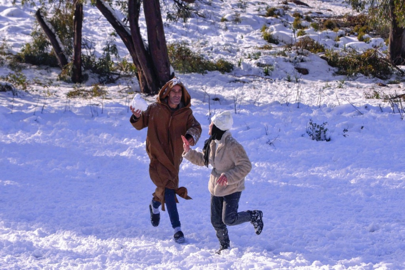 Des Algériens jouent dans la neige à Constantine, dans l’est de l’Algérie, le 23 janvier 2023 (AFP)