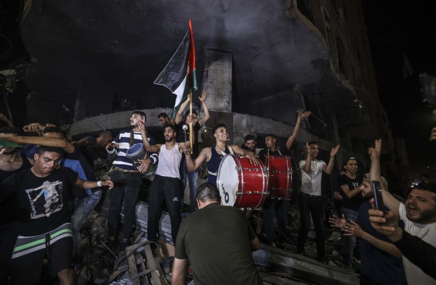 Palestinians celebrate in the street following a ceasefire agreement between Hamas and Israel.