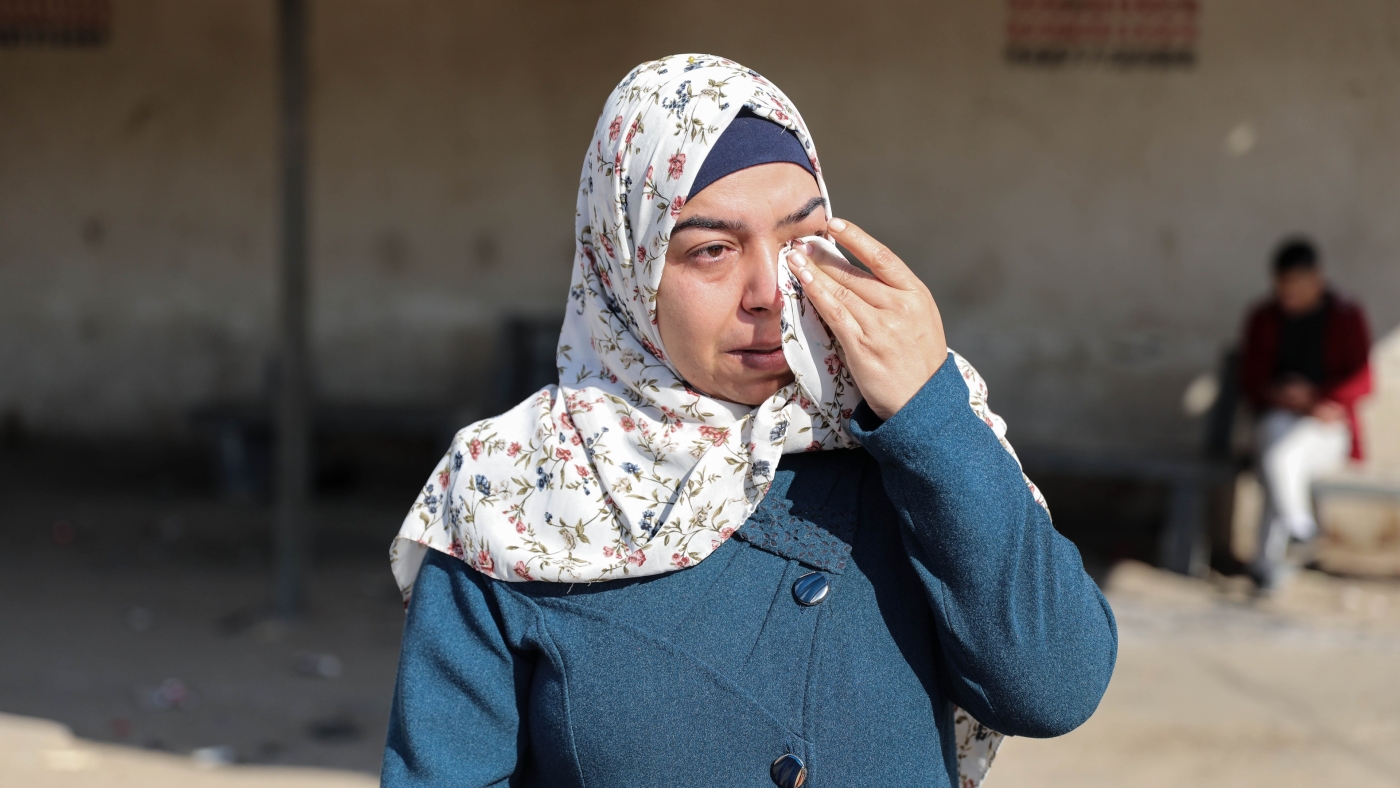 A Palestinian woman wipes away tears at a protest against Israel's 'separation policy' in northern Gaza on 17 January 2023 (MEE/Mohammed al-Hajjar)