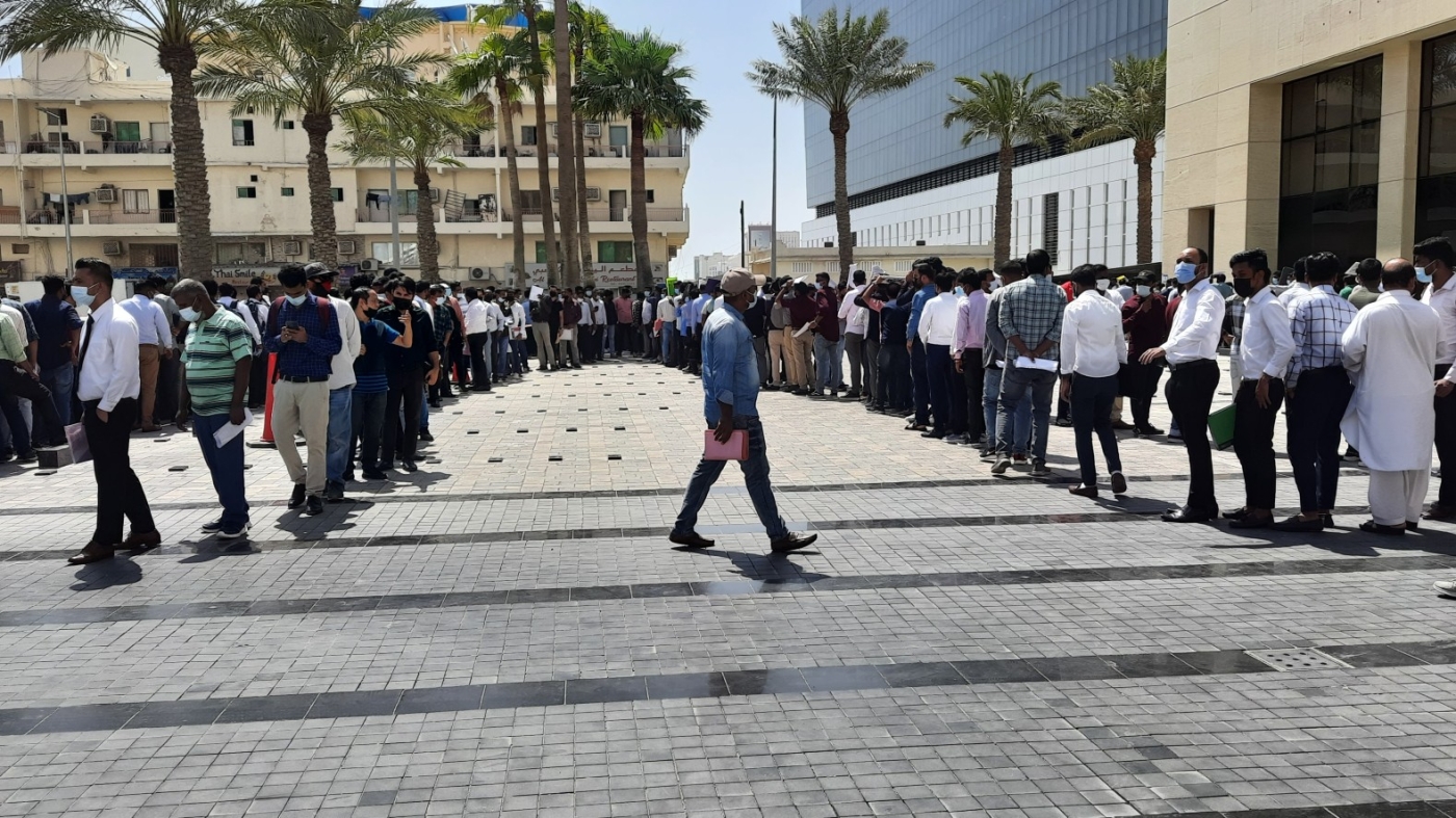 Crowds gather around the Ali Bin Ali Tower at Umm Ghuwailina district of Doha, Qatar, for job interviews on 27 August 2022 (MEE/Harshad Kuttipran)