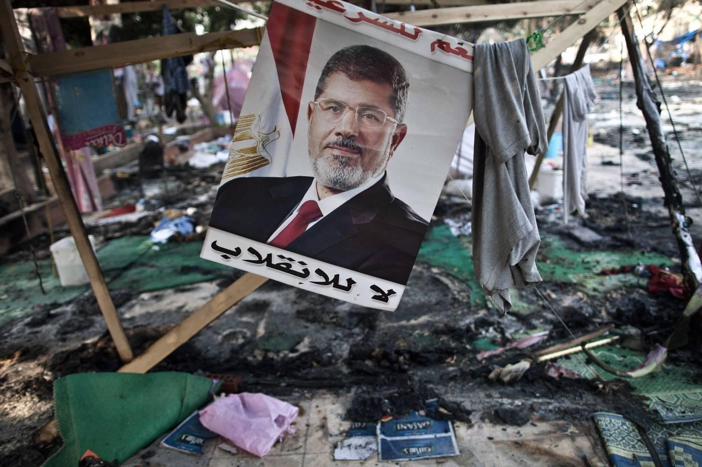 Affiche de Mohamed Morsi dans un camp de ses partisans détruit par l’armée lors du massacre de la place Rabia, en août 2013 (AFP)
